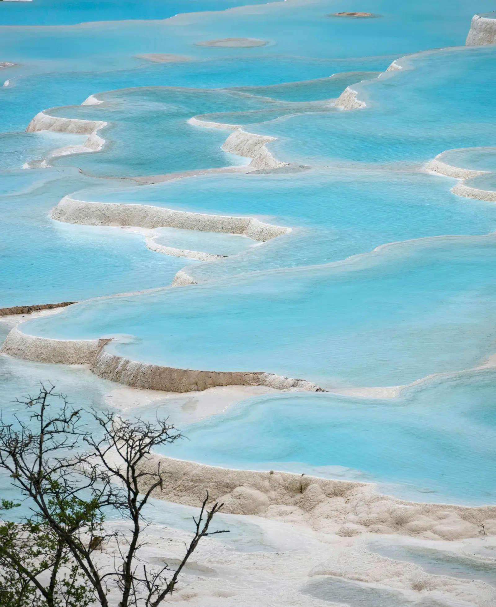Stepped white travertine terraces holding turquoise water at Pamukkale